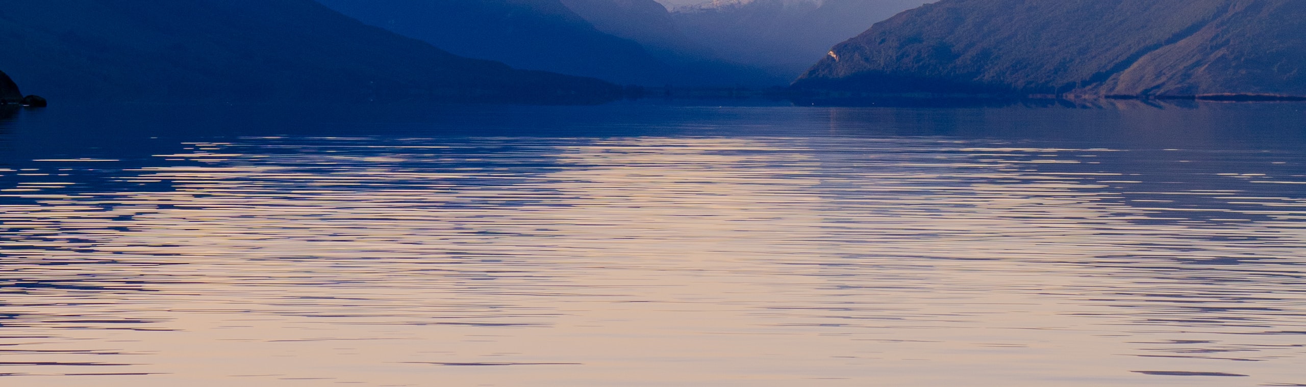 Bergkamm und seine Spiegelung in einem stillen Alpensee